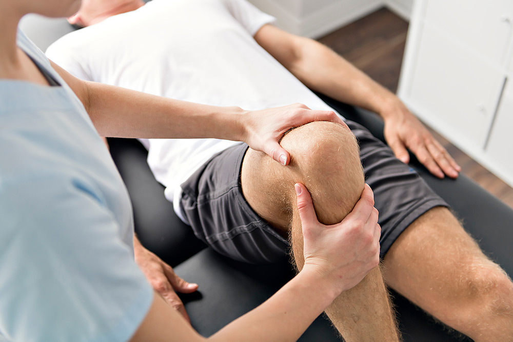 Physiotherapist treating patient's knee